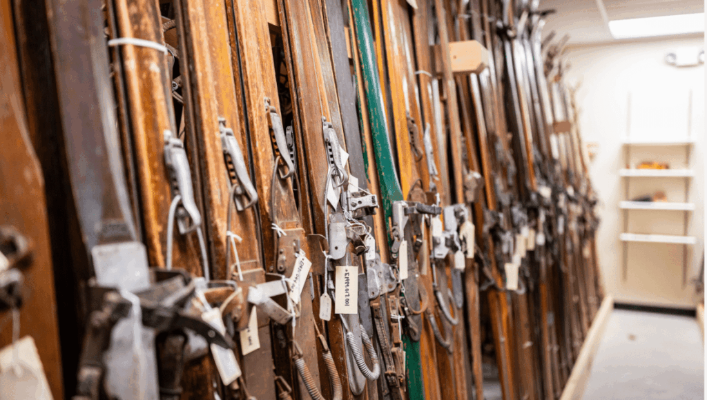 Antique skis lined up against a wall